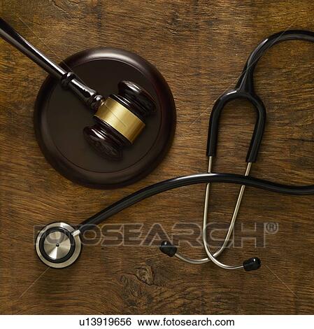 Stock Photograph - Stethoscope and lawers gavel against wooden background.. Fotosearch