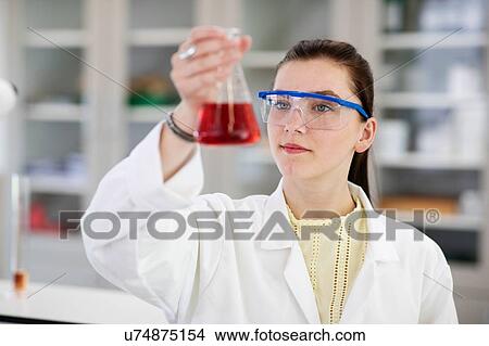 Student analysing sample in flask in laboratory View Large Photo Image Picture - Student analysing sample in flask in laboratory. Fotosearch