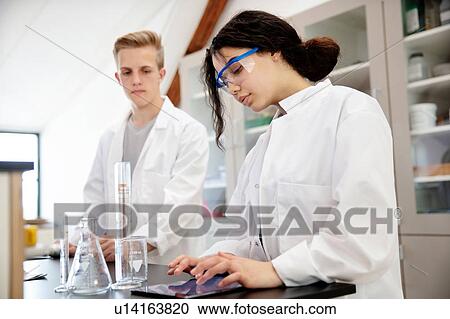 Stock Image - Students using digital tablet in laboratory. Fotosearch