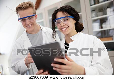 Stock Photo - Students using digital tablet in laboratory. Fotosearch