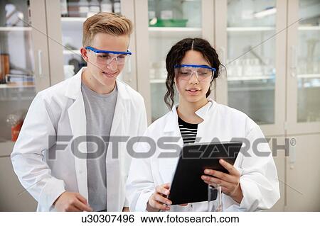 Stock Photograph - Students using digital tablet in laboratory. Fotosearch