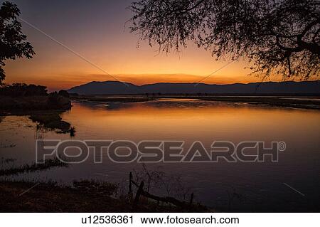 Stock Image - Sunset over Zambezi RIver, Mana Pools, Zimbabwe. Fotosearch