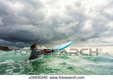 Surfer gliding on ocean wave, Watergate Bay, Cornwall, UK View Large Photo Image Stock Image - Surfer gliding on ocean wave, Watergate Bay, Cornwall, UK. Fotosearch