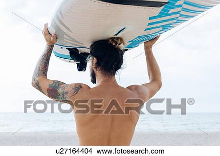 Surfer with surfboard by seaside View Large Photo Image Picture - Surfer with surfboard by seaside. Fotosearch