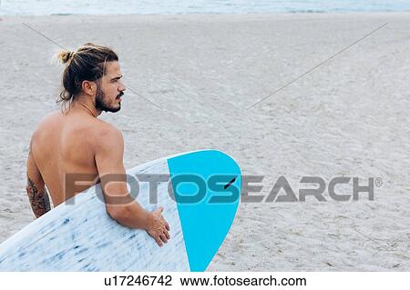 Surfer with surfboard by seaside View Large Photo Image Stock Image - Surfer with surfboard by seaside. Fotosearch