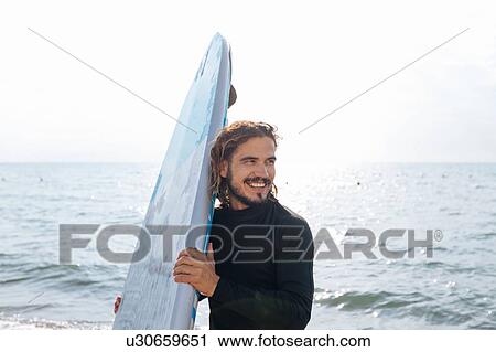Surfer with surfboard by seaside View Large Photo Image Stock Image - Surfer with surfboard by seaside. Fotosearch