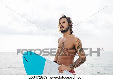 Surfer with surfboard by seaside View Large Photo Image Stock Photo - Surfer with surfboard by seaside. Fotosearch