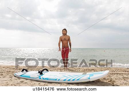 Surfer with surfboard by seaside View Large Photo Image Stock Photograph - Surfer with surfboard by seaside. Fotosearch