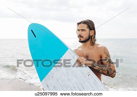 Surfer with surfboard by seaside View Large Photo Image Stock Photography - Surfer with surfboard by seaside. Fotosearch
