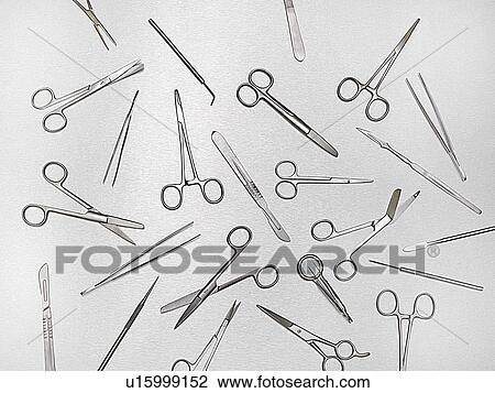 Stock Image - Surgical scissors against a grey background.. Fotosearch