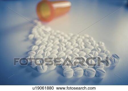 Stock Image - Tablets spilling from bottle.. Fotosearch