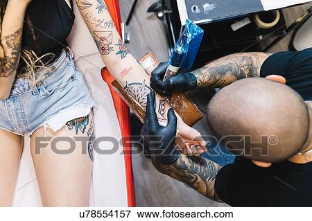Stock Photo - Tattooist drawing on arm of customer. Fotosearch