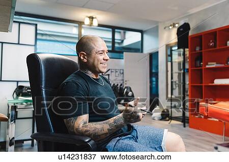 Tattooist taking break in parlour View Large Photo Image Stock Photo - Tattooist taking break in parlour. Fotosearch