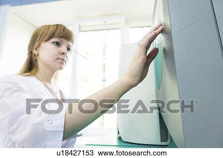 Stock Image - Technician working autoclave.. Fotosearch