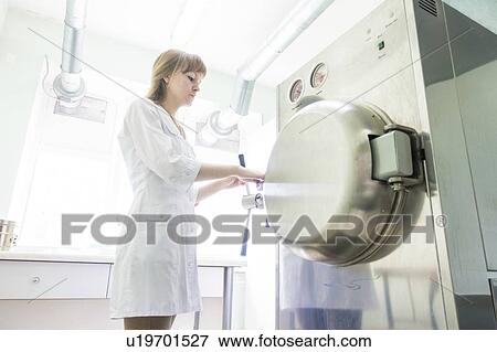 Stock Photo - Technician working autoclave.. Fotosearch