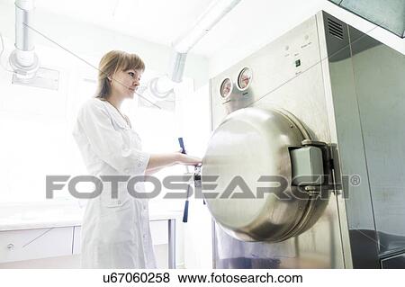 Stock Photo - Technician working autoclave.. Fotosearch