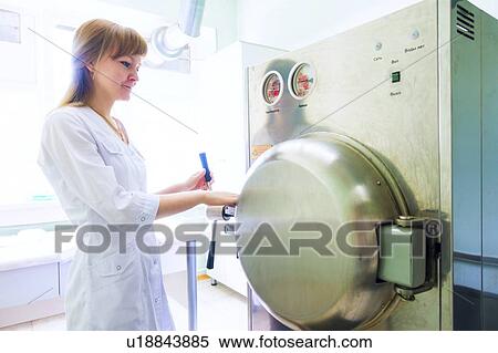 Stock Photography - Technician working autoclave.. Fotosearch