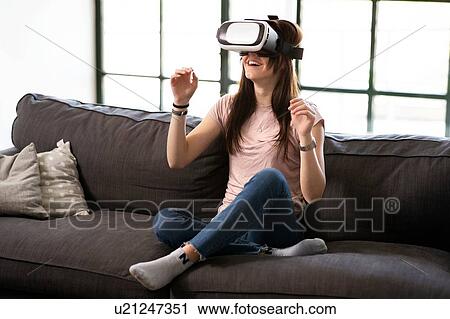 Teenage girl on sofa looking through virtual reality headset View Large Photo Image Stock Image - Teenage girl on sofa looking through virtual reality headset. Fotosearch