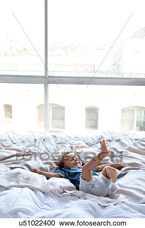 Toddler playing on bed View Large Photo Image Stock Image - Toddler playing on bed. Fotosearch
