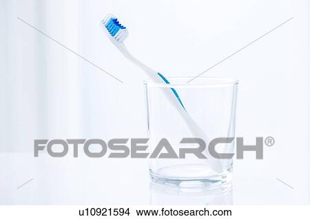 Toothbrush in glass against a plain background. View Large Photo Image Picture - Toothbrush in glass against a plain background.. Fotosearch