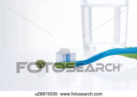 Toothbrush with a pea sized amount of toothpaste against a white background. View Large Photo Image Stock Photography - Toothbrush with a pea sized amount of toothpaste against a white background.. Fotosearch