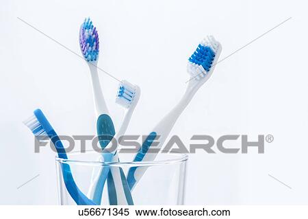 Toothbrushes in glass against a plain background. View Large Photo Image Stock Photography - Toothbrushes in glass against a plain background.. Fotosearch