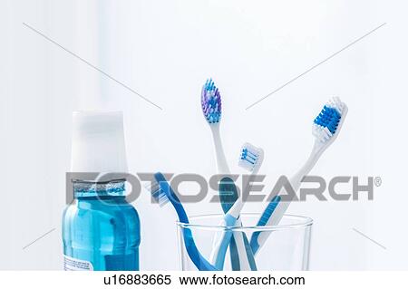 Toothbrushes in glass with mouthwash against a plain background. View Large Photo Image Stock Photography - Toothbrushes in glass with mouthwash against a plain background.. Fotosearch