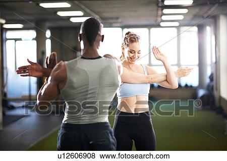 Trainer and female client doing stretching exercise in gym View Large Photo Image Stock Photo - Trainer and female client doing stretching exercise in gym. Fotosearch
