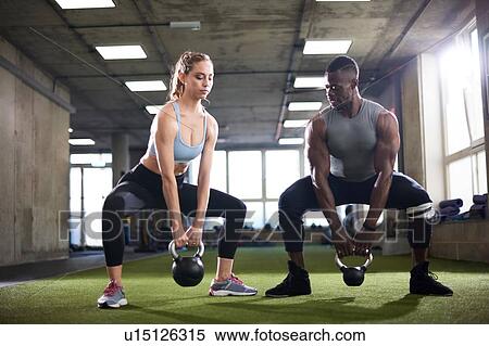 Trainer and female client exercise with kettlebells in gym View Large Photo Image Stock Photography - Trainer and female client exercise with kettlebells in gym. Fotosearch