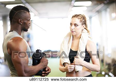 Trainer and female client talking in gym View Large Photo Image Stock Photography - Trainer and female client talking in gym. Fotosearch
