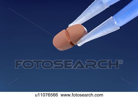 Stock Photograph - Tweezers holding pill.. Fotosearch