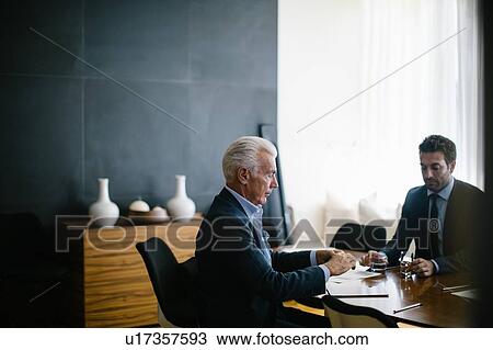 Two businessmen meeting at boardroom table View Large Photo Image Stock Image - Two businessmen meeting at boardroom table. Fotosearch