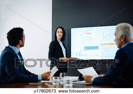 Stock Image - Two businessmen meeting at boardroom presentation. Fotosearch