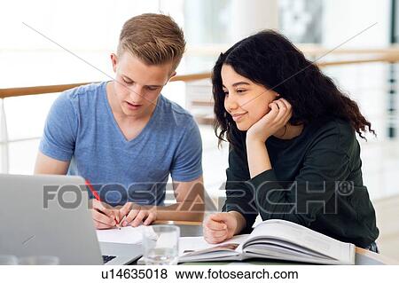 Stock Photo - Two high school students at classroom desk working on laptop. Fotosearch