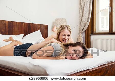 Two women lying on bed, portrait View Large Photo Image Stock Photograph - Two women lying on bed, portrait. Fotosearch