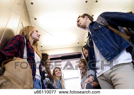 Stock Photo - University students talking inside elevator. Fotosearch