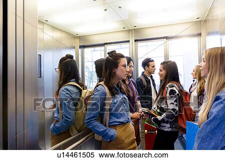 Stock Photography - University students talking inside elevator. Fotosearch