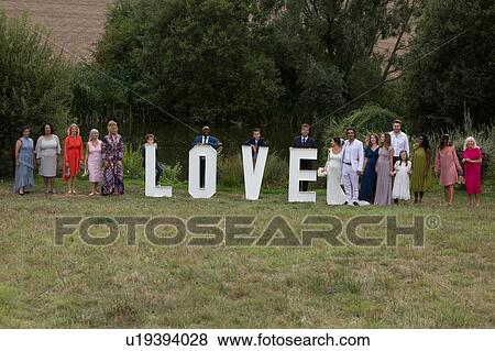 Wedding guests posing behind love word View Large Photo Image Stock Photo - Wedding guests posing behind love word. Fotosearch