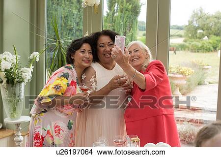 Wedding guests taking selfie at reception View Large Photo Image Picture - Wedding guests taking selfie at reception. Fotosearch