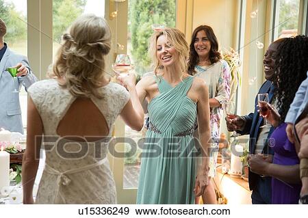 Wedding guests toasting to newlyweds at reception View Large Photo Image Stock Photo - Wedding guests toasting to newlyweds at reception. Fotosearch