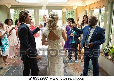 Stock Photo - Wedding guests toasting to newlyweds at reception. Fotosearch