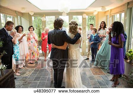 Wedding guests toasting to newlyweds at reception View Large Photo Image Stock Photo - Wedding guests toasting to newlyweds at reception. Fotosearch