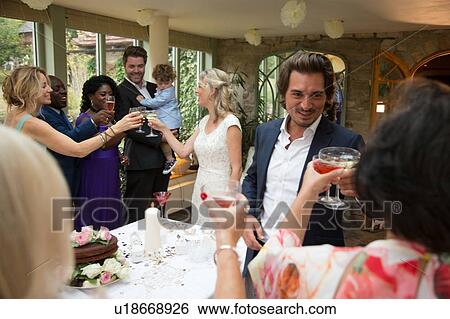 Stock Photograph - Wedding guests toasting to newlyweds at reception. Fotosearch