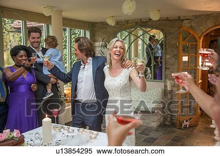 Wedding guests toasting to newlyweds at reception View Large Photo Image Stock Photography - Wedding guests toasting to newlyweds at reception. Fotosearch