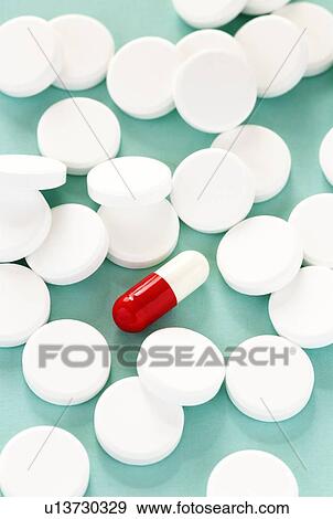 Stock Photo - White pills surrounding a red and white capsule.. Fotosearch