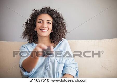 Woman 0essing remote control on sofa View Large Photo Image Stock Image - Woman 0essing remote control on sofa. Fotosearch
