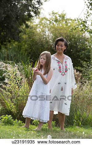 Stock Photography - Woman and girl enjoying garden. Fotosearch