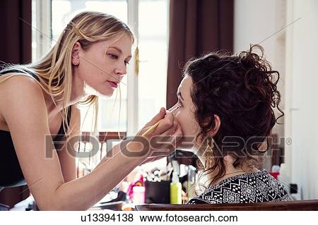 Woman applying friend's eye liner in bedroom View Large Photo Image Stock Photo - Woman applying friend's eye liner in bedroom. Fotosearch