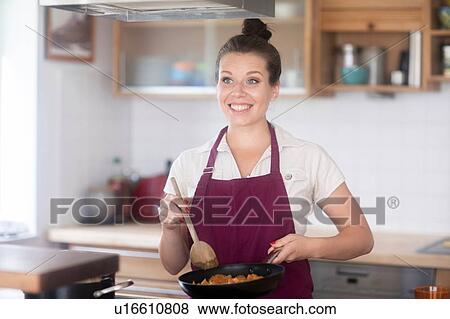 Stock Photo - Woman cooking in kitchen. Fotosearch