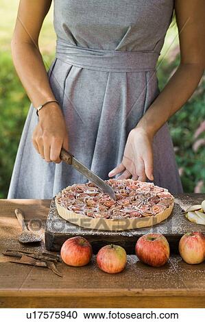 Woman cutting apple pie on table View Large Photo Image Stock Image - Woman cutting apple pie on table. Fotosearch